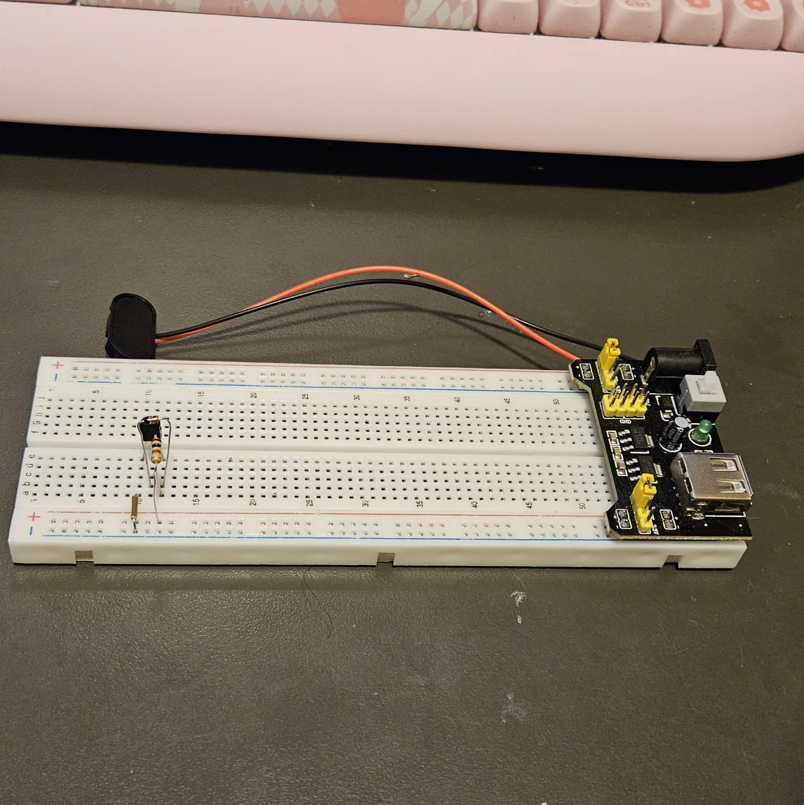 A small glass diode added to the board, standing on bent legs beside the transistor with its dark band toward the transistor's middle leg.
