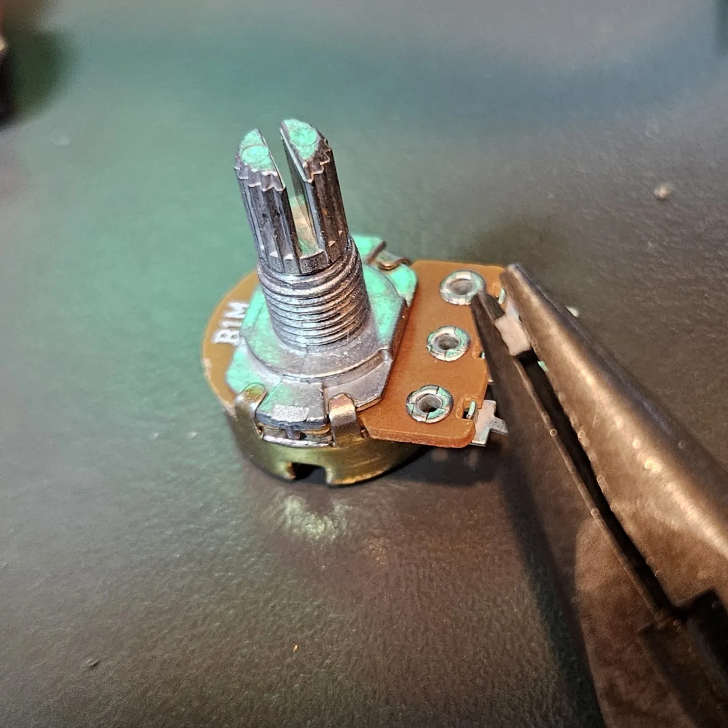 The B1M pot with its anti-rotation tab removed, leaving a clean stub where the tab used to be.