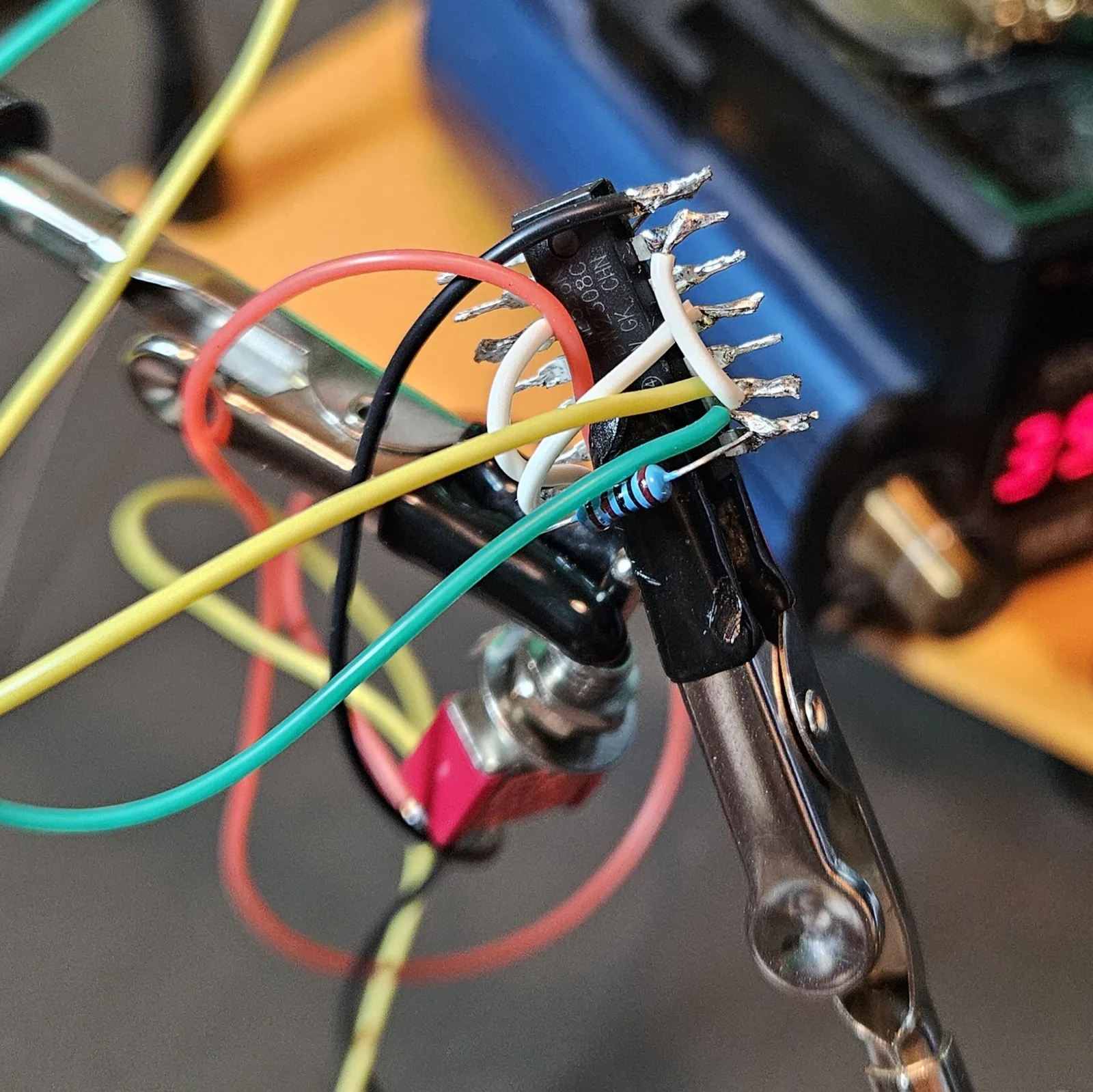 The pitch pot's green and yellow leads run down to the chip and soldered in, joining the 1K resistor and reset jumpers on the dead-bug NE556.