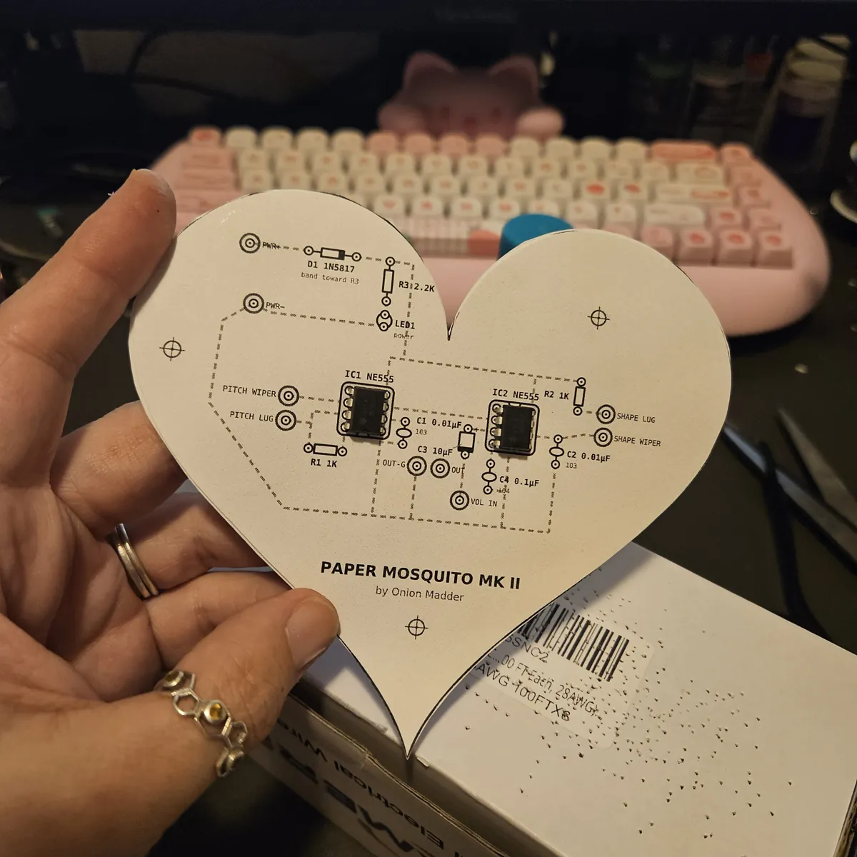 Both chips pushed into their holes on the front of the heart, sitting flat on the paper.
