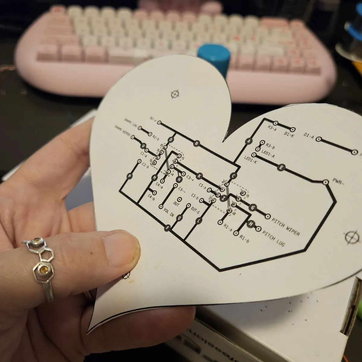 The back of the heart with the chips in: the chips’ legs poke through the paper among the black traces.