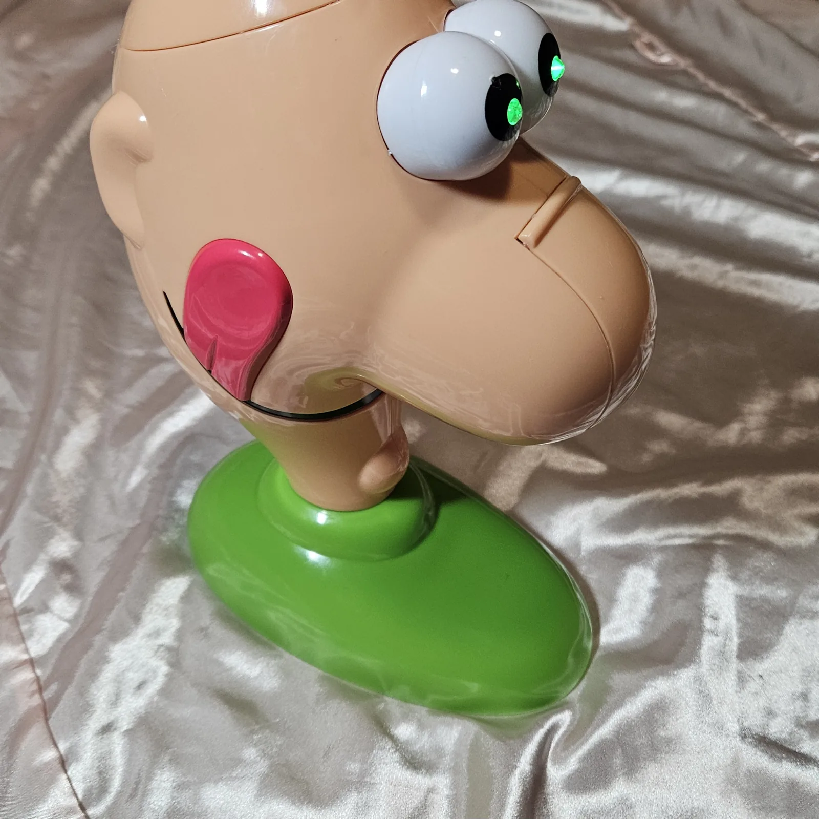 Loopy Louie, finished - a repurposed Gooey Louie game head (a bald, big-nosed cartoon man on a green oval base) with its big white googly eyes glowing bright green from LEDs set into the pupils.