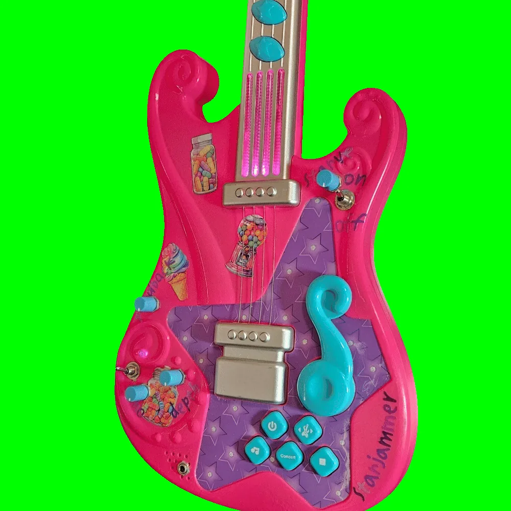 The same guitar in a dim room with the lights running: the four clear plastic string strips on the neck glow hot magenta-pink from end to end, and a smaller pink glow shows inside the molded swirl at the lower left of the body. The added knobs, toggles and marker labels stay visible in the low light.