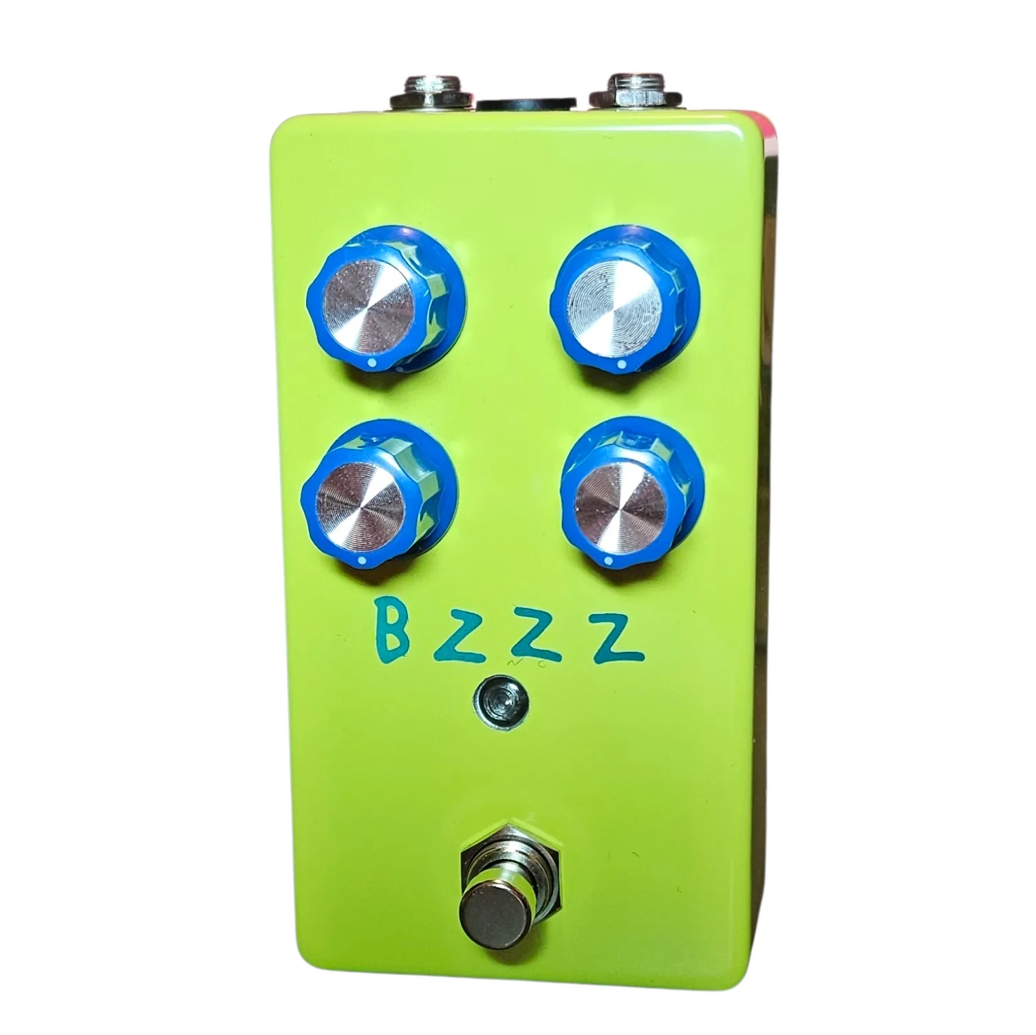 Bzzz pedal, front view - a neon-yellow-green enclosure with four chunky blue-and-silver knobs in a 2x2 grid, a small green LED beneath, a 3PDT footswitch at the bottom, and BZZZ hand-lettered in teal marker under the knobs.