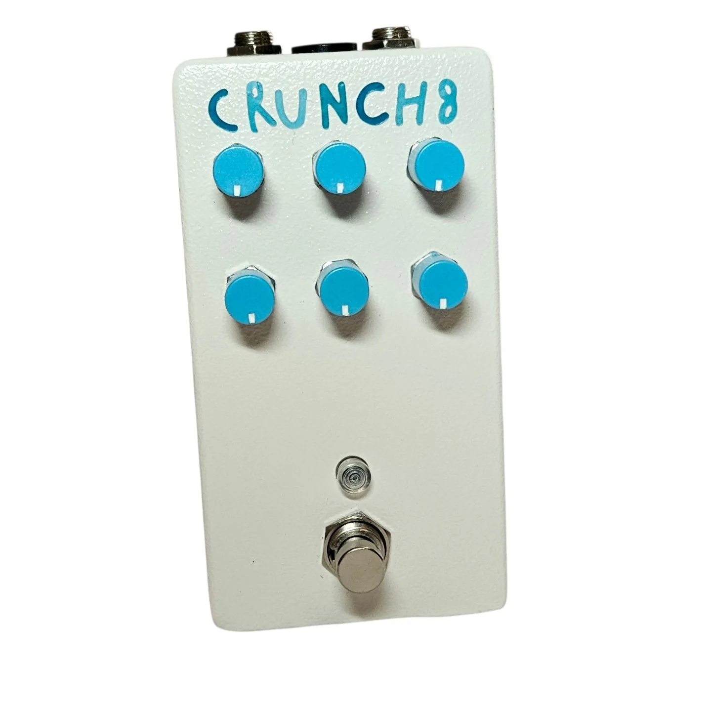 A white pedal with a lightly textured finish, photographed face on, with CRUNCH8 hand-painted across the top in bright blue capitals. Six sky-blue knobs stand in two rows of three below the lettering, a small LED sits under them, and a silver footswitch is at the bottom.
