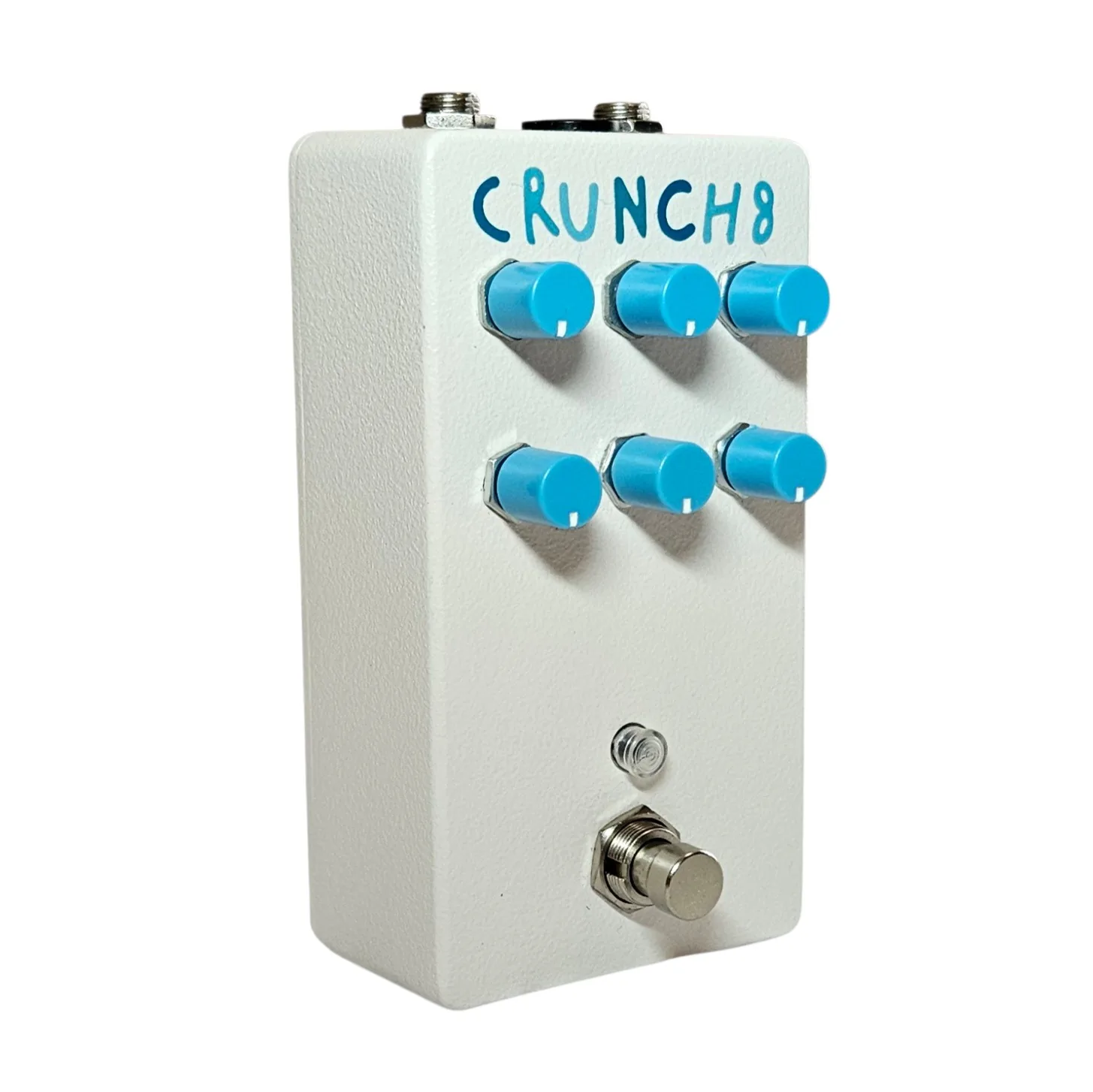 The pedal turned three quarters to show its depth, the six blue knobs ranged across the sloping white face and the blue CRUNCH8 lettering still legible along the top. Jack sockets show along the back edge.