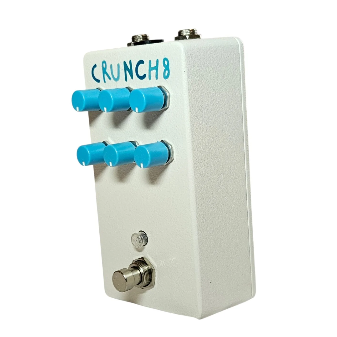 The pedal from the opposite three-quarter angle, the two rows of blue knobs strongly foreshortened and standing well proud of the white enclosure, with the footswitch at the lower corner.