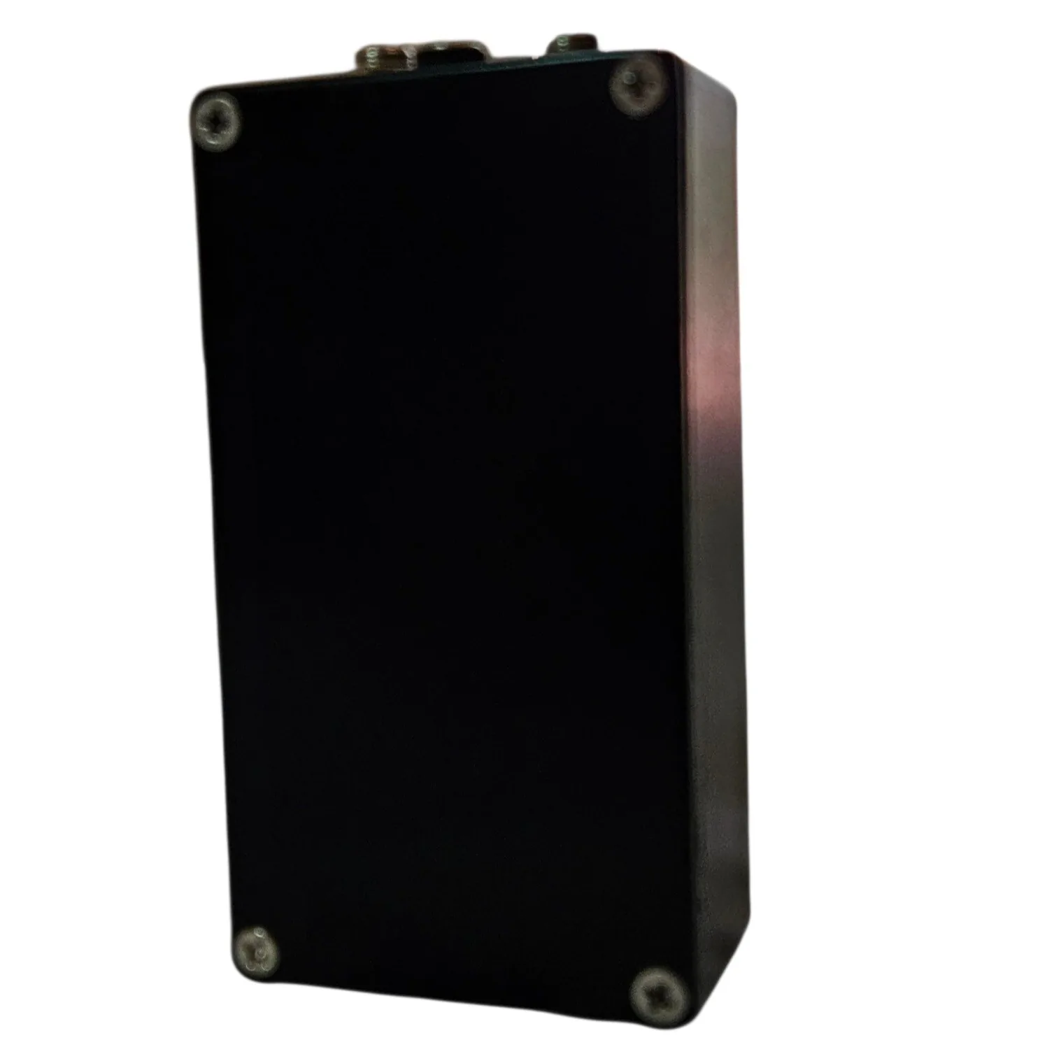 The back of the pedal: a plain black bottom plate with a cross-head screw in each corner, and the jack sockets and power socket visible along the top edge.