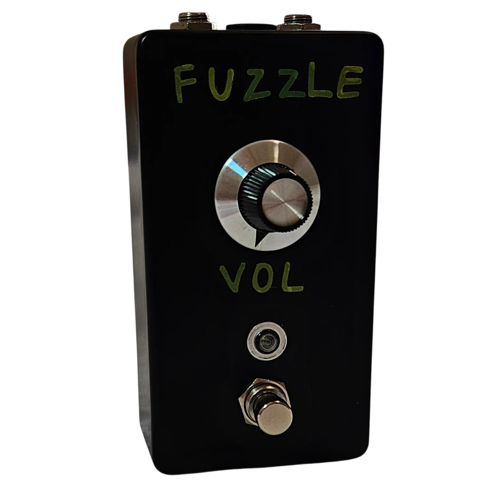 A tall black pedal photographed face on. Hand-painted green capital letters spell FUZZLE across the top and VOL below the knob. A single large knob with a silver collar and a pointer line sits in the middle, a small round LED below it, and a silver footswitch at the bottom.
