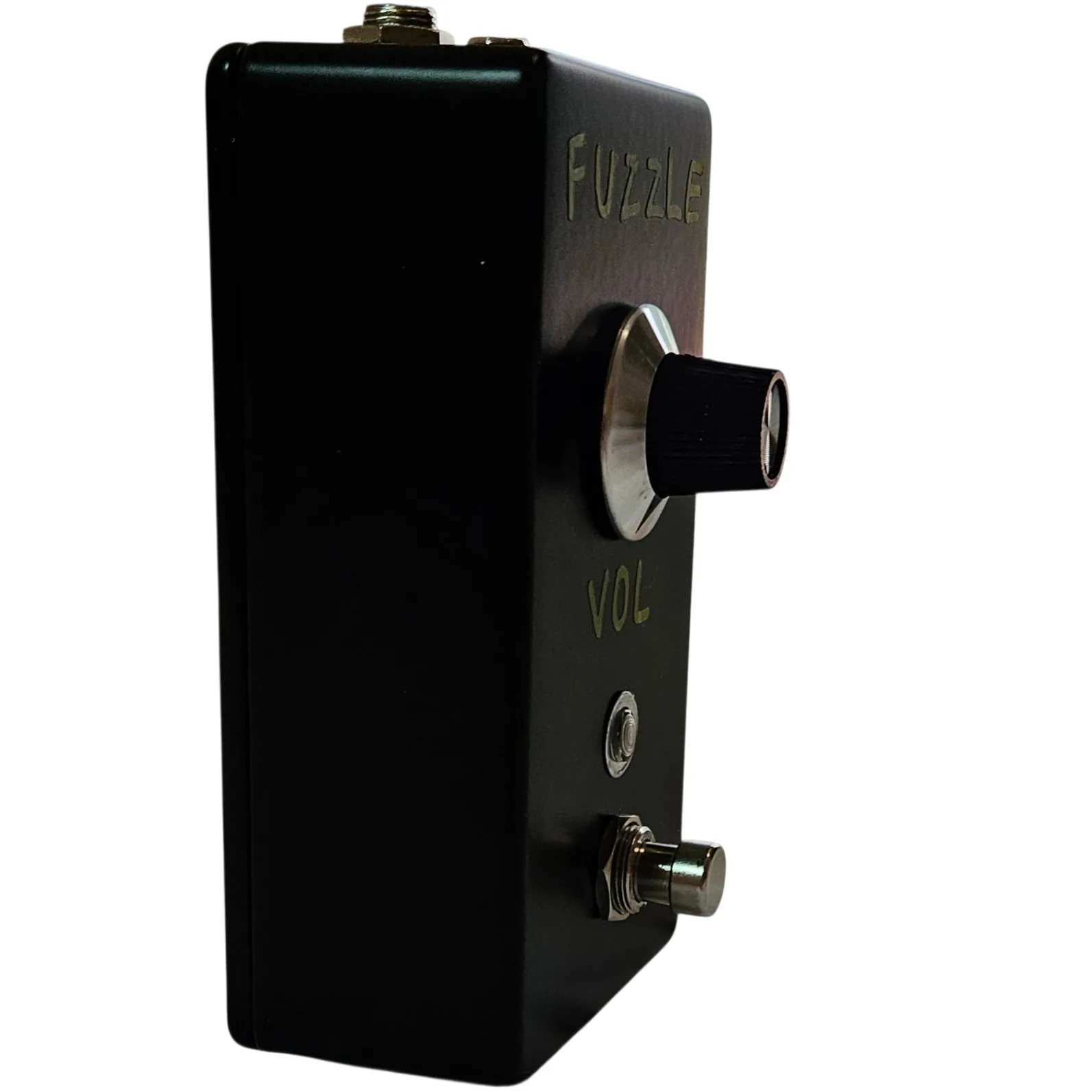 The pedal turned three quarters, its plain black flank running back from the face. The green FUZZLE lettering reads down the top edge and the knob stands out in profile against the background.
