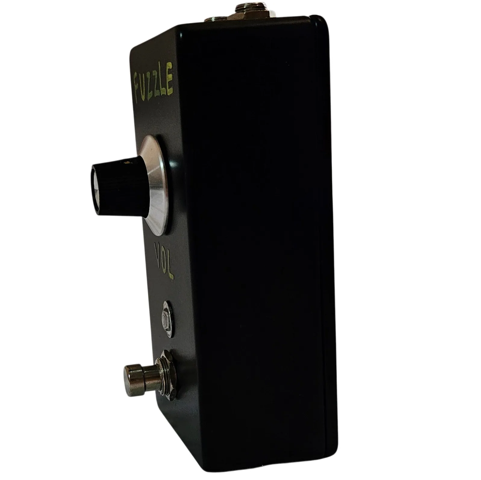 A near-side-on view of the pedal, showing how shallow the box is. The knob projects from the face at the left, VOL is painted in green beneath it, and the footswitch sticks out at the bottom corner.