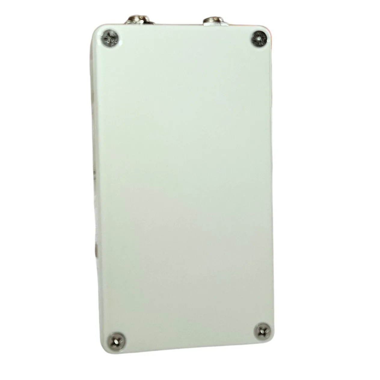The back of the pedal: a plain white bottom plate with a cross-head screw in each corner and the jack sockets showing along the top edge.