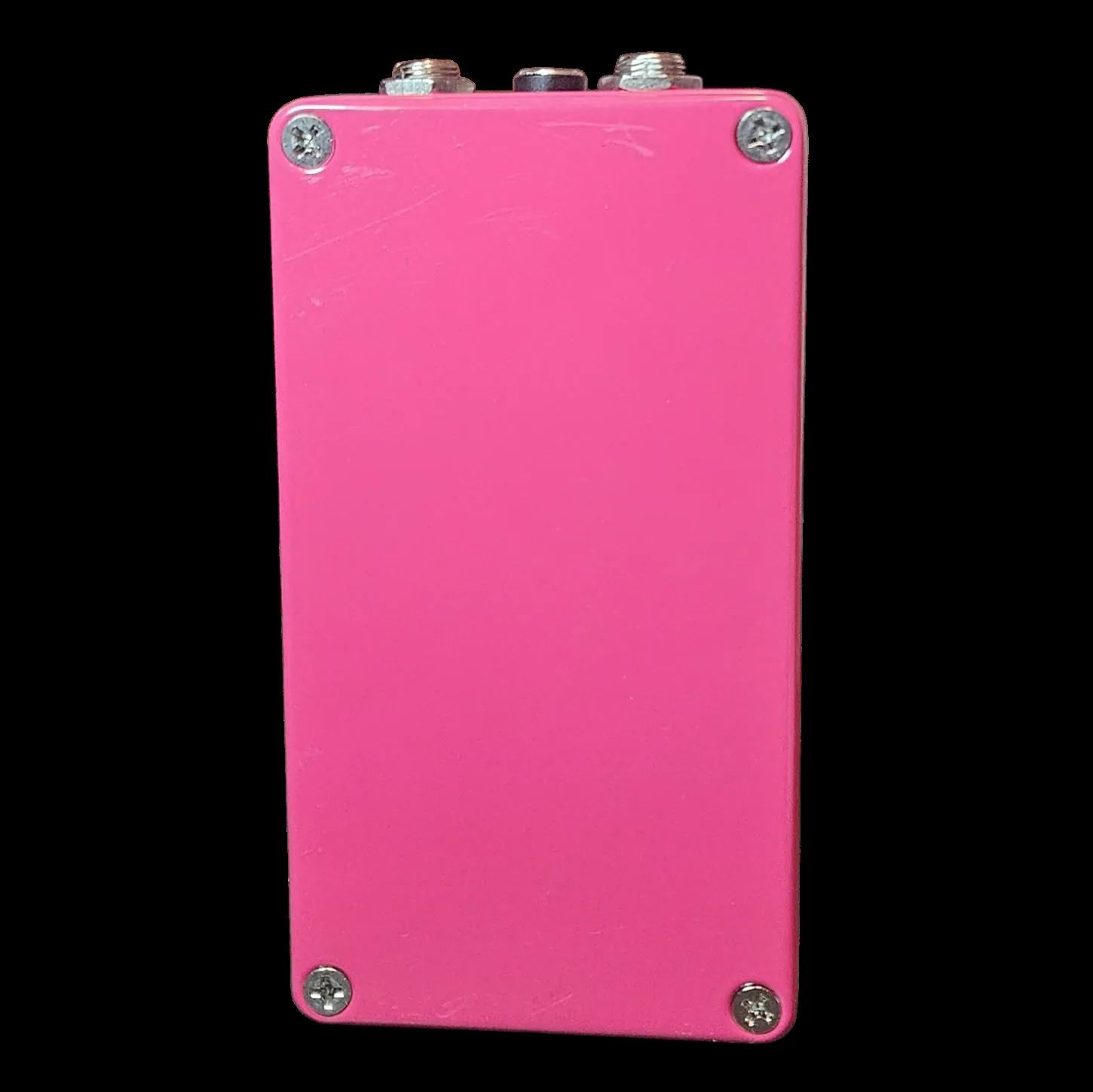 The back of the pedal, a plain hot pink plate held on by four silver countersunk screws, with the three jack nuts showing along the top edge.