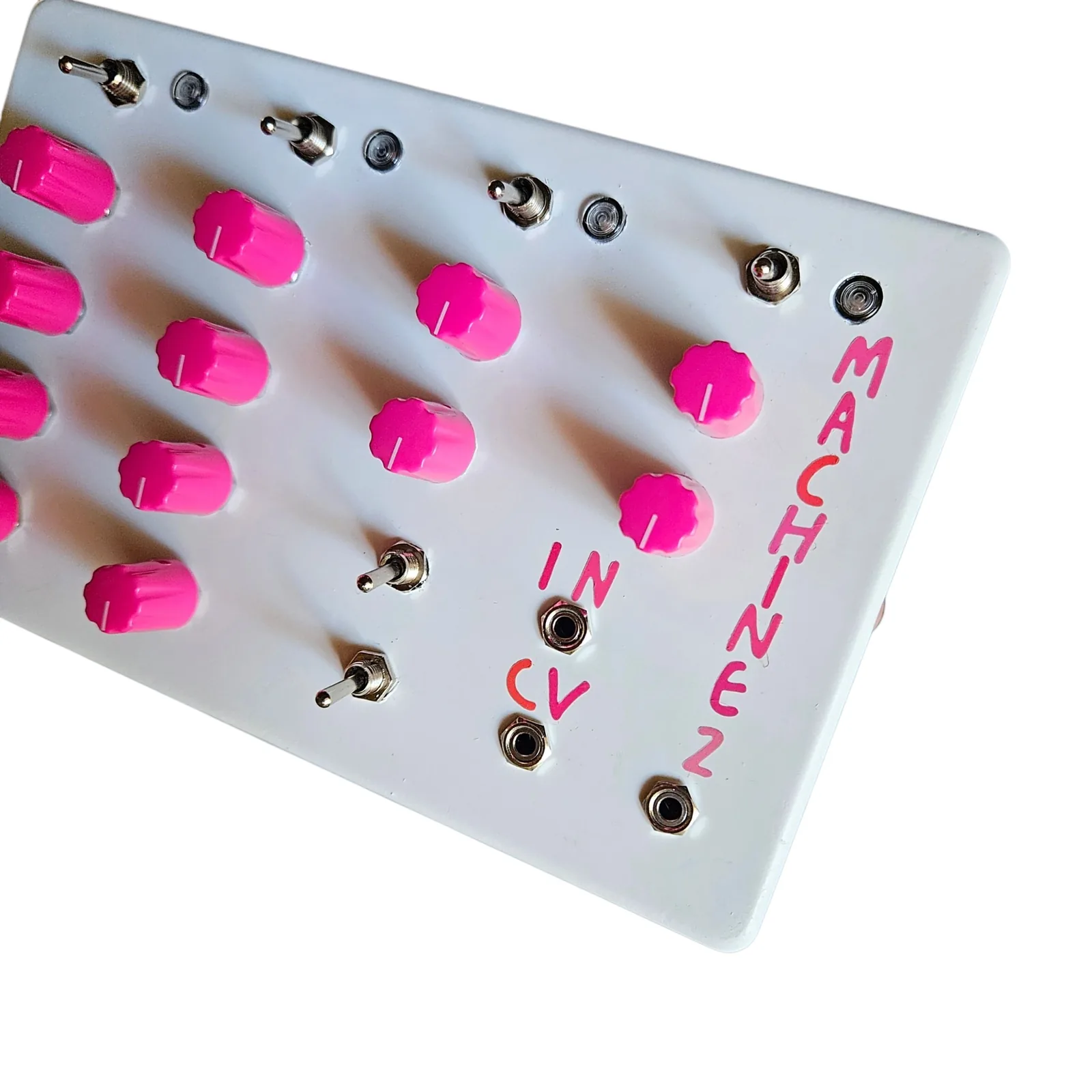 A close three-quarter of the right-hand end of the face: pink knobs, the IN and CV lettering beside their jacks, MACHINE 2 down the edge in pink, and the toggles with their LEDs along the top.