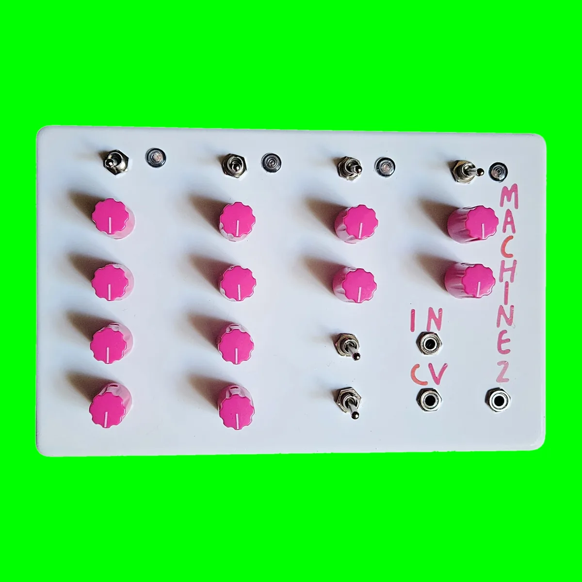 A wide white box lying flat, seen face on. Twelve hot pink knobs stand in four columns: four in each of the first two, two in the third above two small toggles, and two in the fourth. A row of four small toggles runs across the top with a round LED beside each. MACHINE 2 is hand-lettered in pink down the right edge, and IN and CV are lettered beside two jacks at the lower right, with a third jack in the corner.