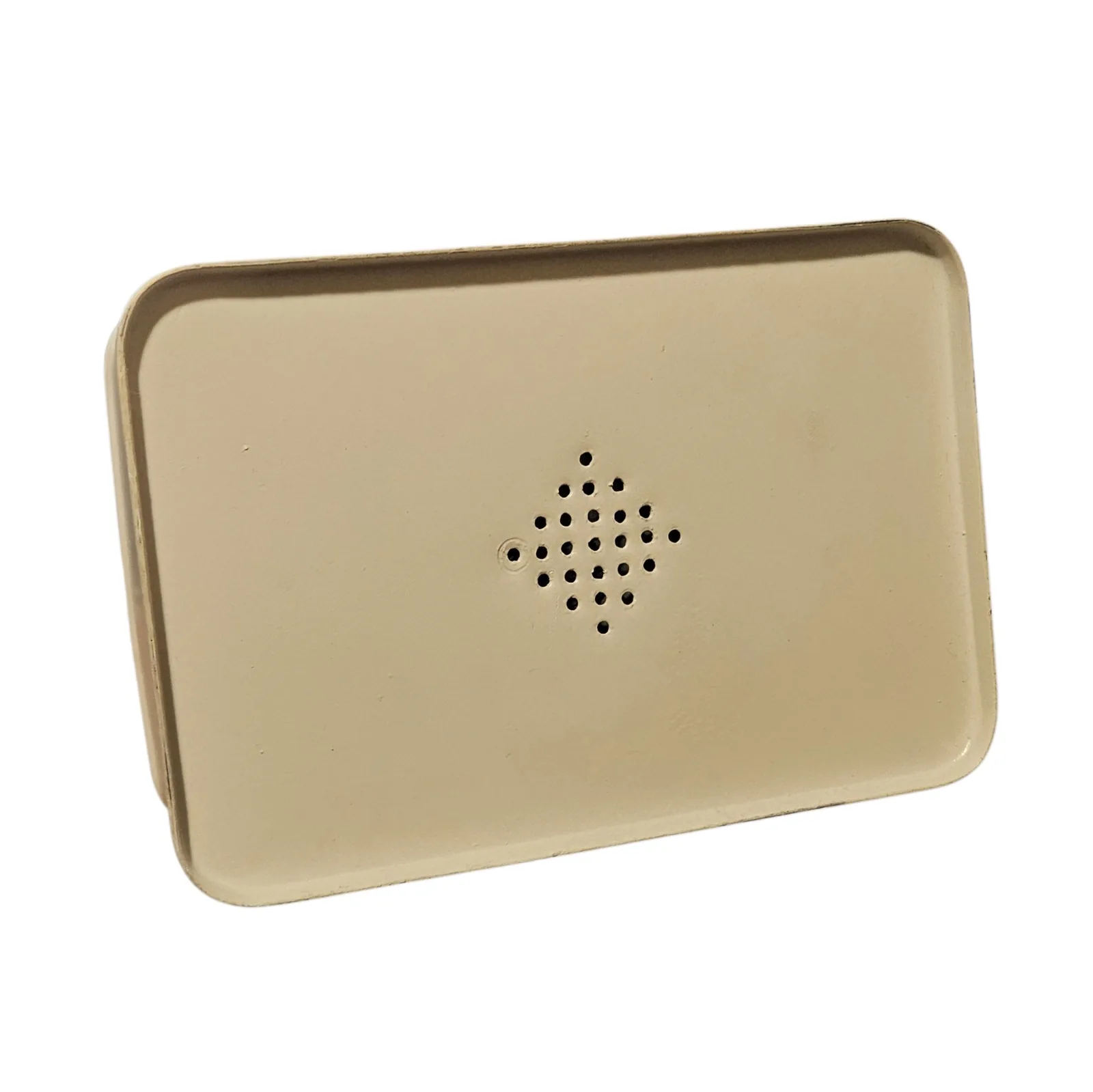 The bottom of the tin: a plain cream-painted panel with a diamond of small drilled holes in the middle, twenty-five of them, seven across at the widest row. The hole at the left-hand point sits in a shallow dimple in the paint.