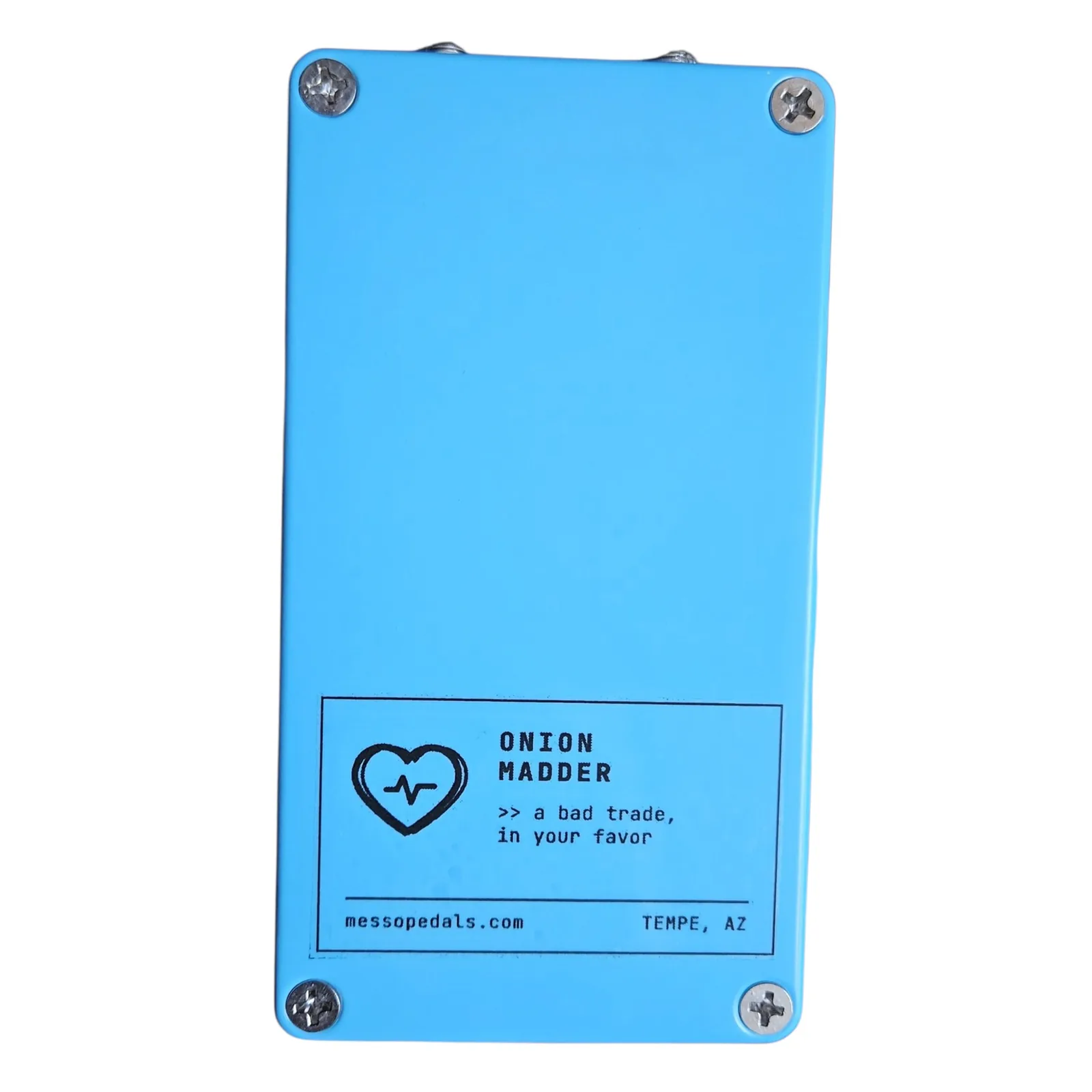 The back plate of the blue box with a screw in each corner and a white label near the bottom: a heart with a heartbeat line, ONION MADDER, a bad trade, in your favor, messopedals.com and TEMPE, AZ.
