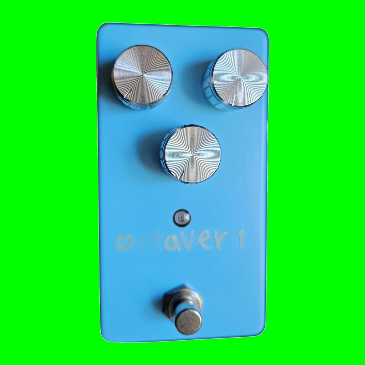 A matte sky blue box stood upright, seen face on. Two silver knurled knobs sit side by side near the top with a third centered below them, a small indicator LED under that, octaver 1 lettered faintly in pale paint, and a chrome footswitch at the bottom.
