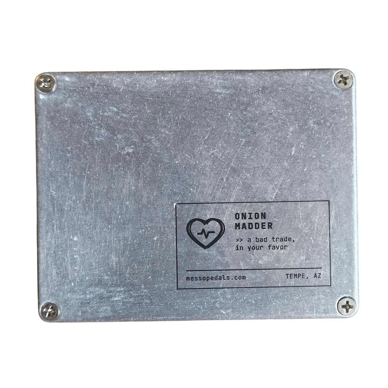 The back of the aluminum box: a Phillips screw in each corner and a printed label in the lower right with a heart logo, reading Onion Madder, a bad trade, in your favor, messopedals.com, Tempe, AZ.