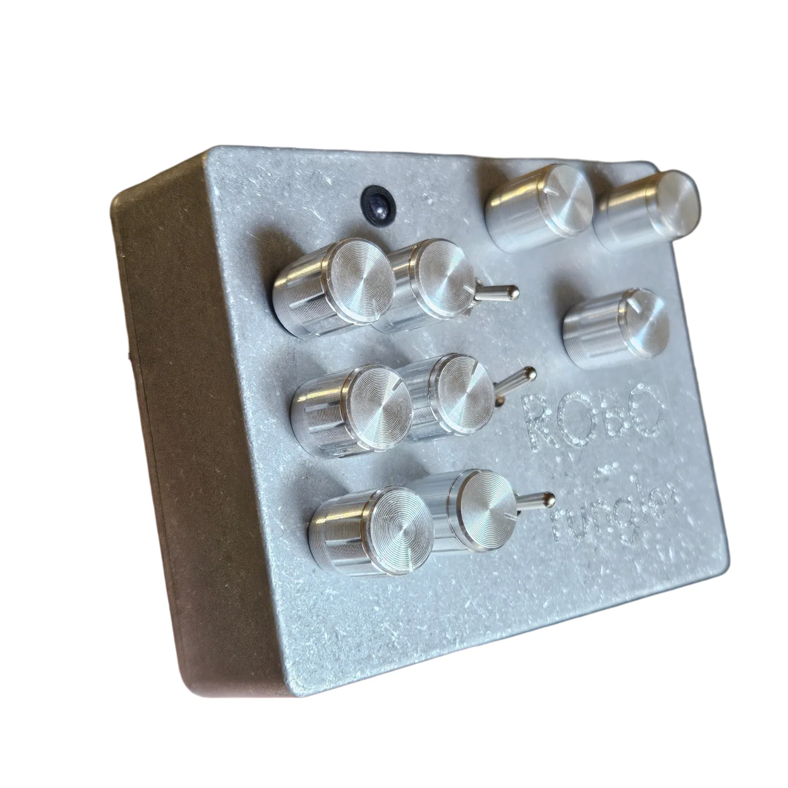 The Robo Rungler from the left at a three-quarter angle: the six knobs in pairs with a toggle beside each pair, three more knobs at the right, the LED near the top, and ROBO rungler engraved on the face.