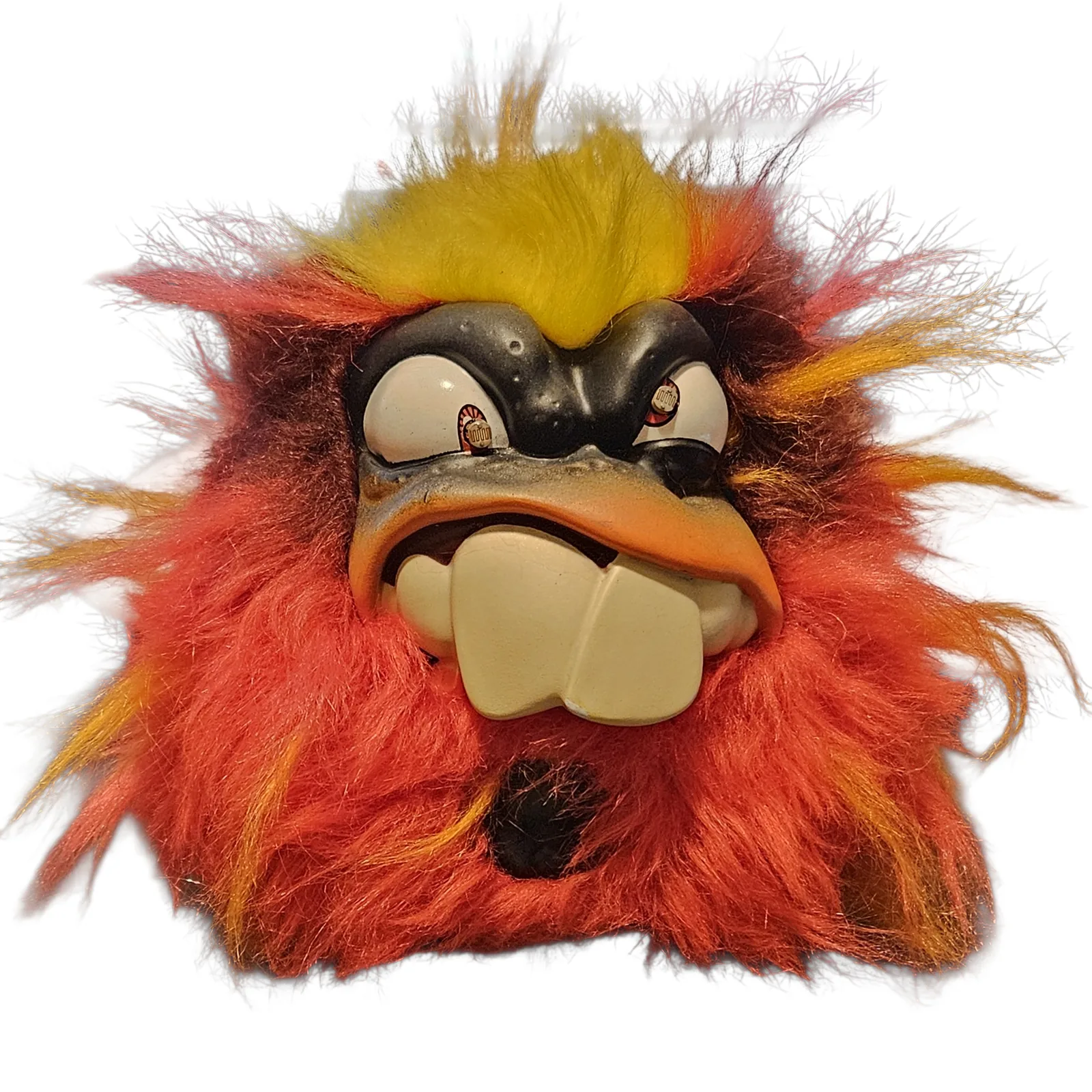 The Screaming Creep face on against white: a round toy monster covered in shaggy red, orange and yellow fur with a yellow tuft standing up on top, a hard plastic face with heavy black brows and two big cream teeth, and a dark photocell set into each pupil.