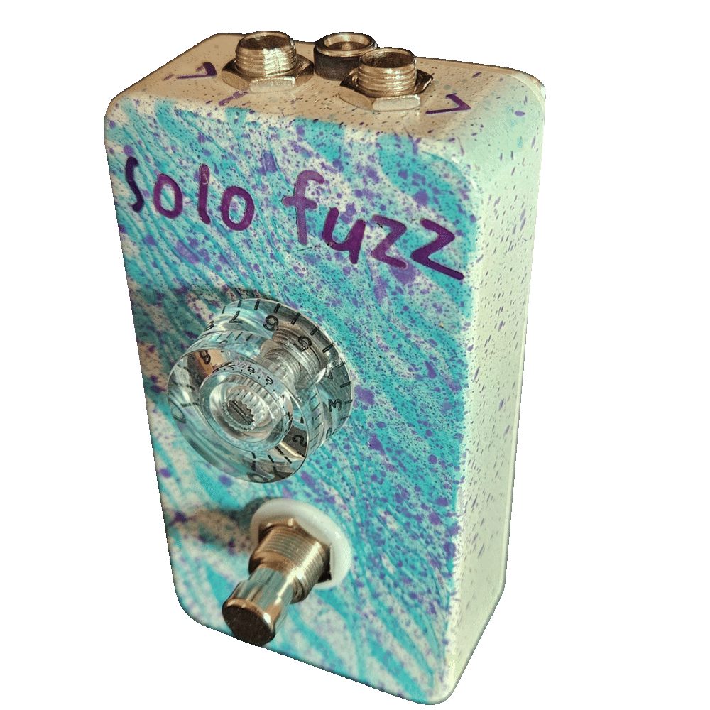 Top-down view of the enclosure: a 1/4-inch jack sits at each corner of the top edge with a black DC power jack between them, and the jacks carry no legible labels. Hand-lettered purple "solo fuzz" sits above the single clear knob.