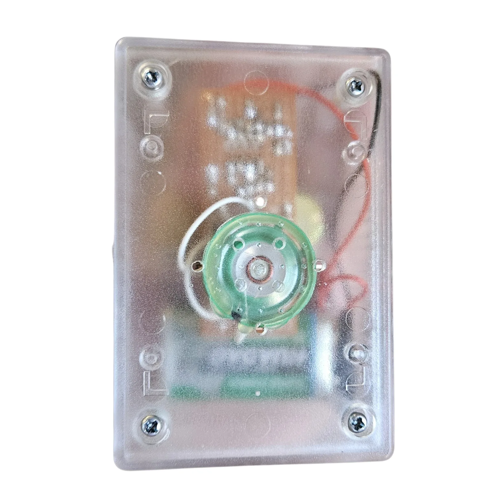 The back of the clear box with its four corner screws, the board, the wiring and the battery blurred through the plastic. A round green speaker with a white wire to it is fixed in the middle.