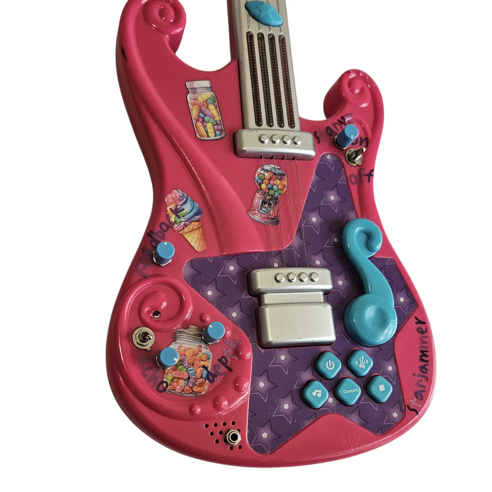 The body from a lower angle, showing the same cluster of teal buttons and the sticker collage with the neck running away behind it.