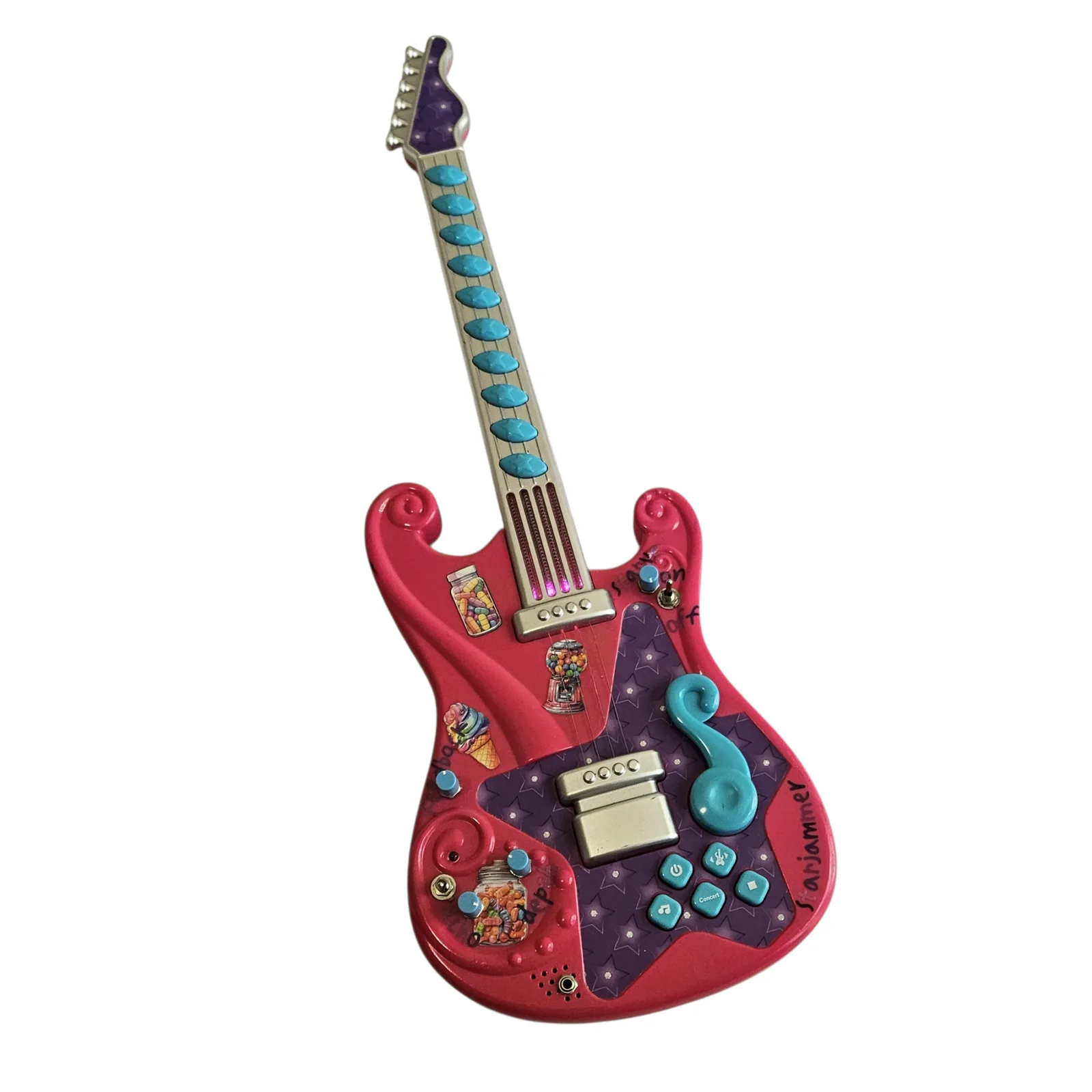 The Starjammer photographed front on: a bright pink toy guitar with a cream and purple fretboard dotted with teal position markers, its body covered in a collage of candy and food stickers, a teal treble clef, rows of small teal buttons and a silver rocker, with Starjammer hand-lettered along the lower edge.