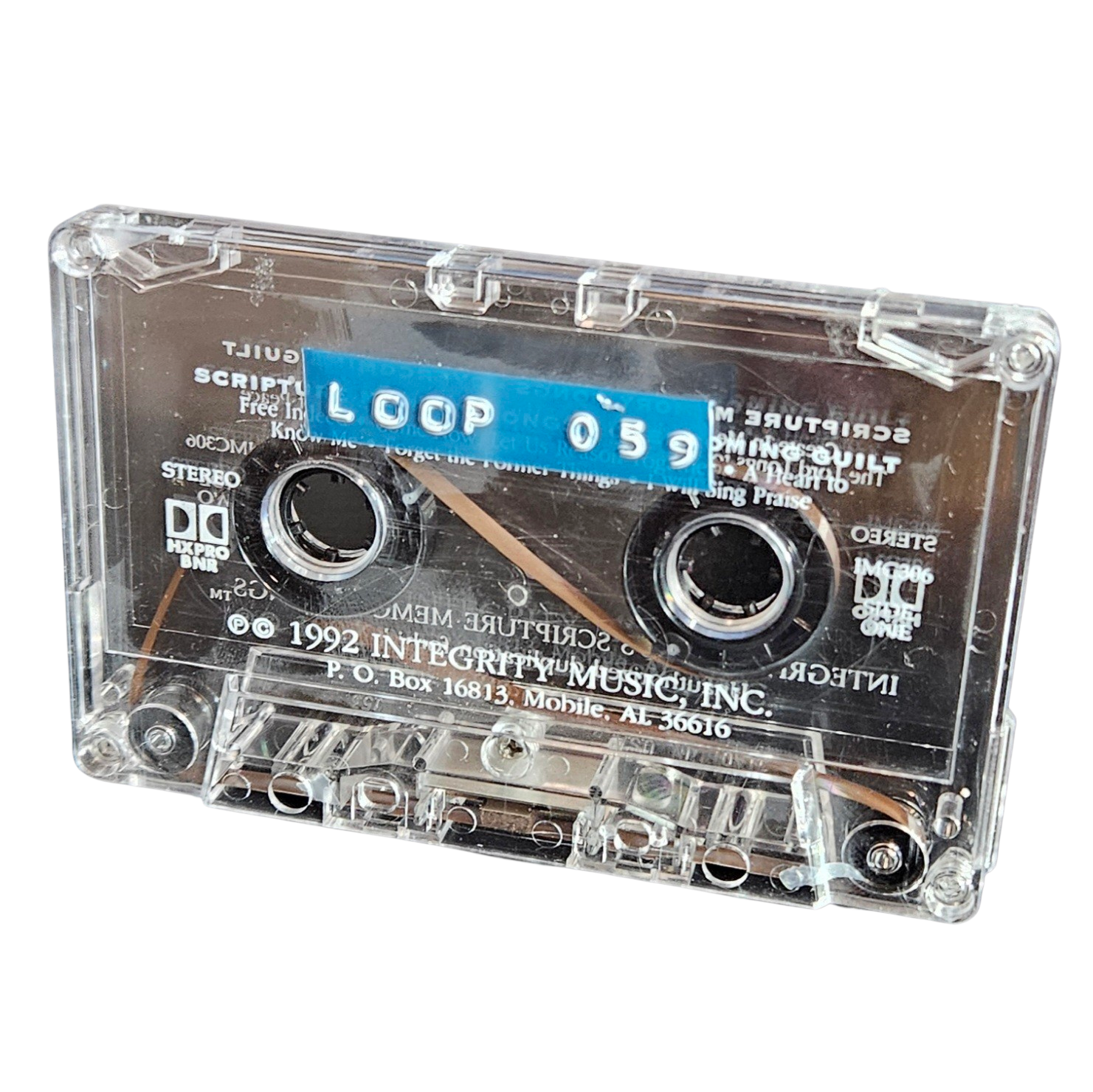 Clear cassette shell labeled Loop 059 on a blue strip, recycled from a 1992 Integrity Music scripture cassette