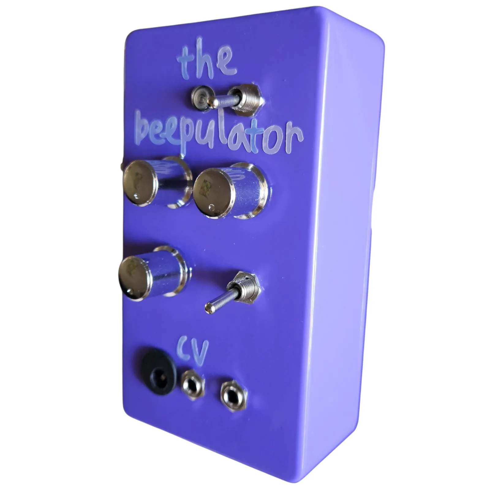 The purple box at a three-quarter angle from the right, the knobs, toggles and the cv lettering along the face and the long plain side of the box filling the left of the frame.