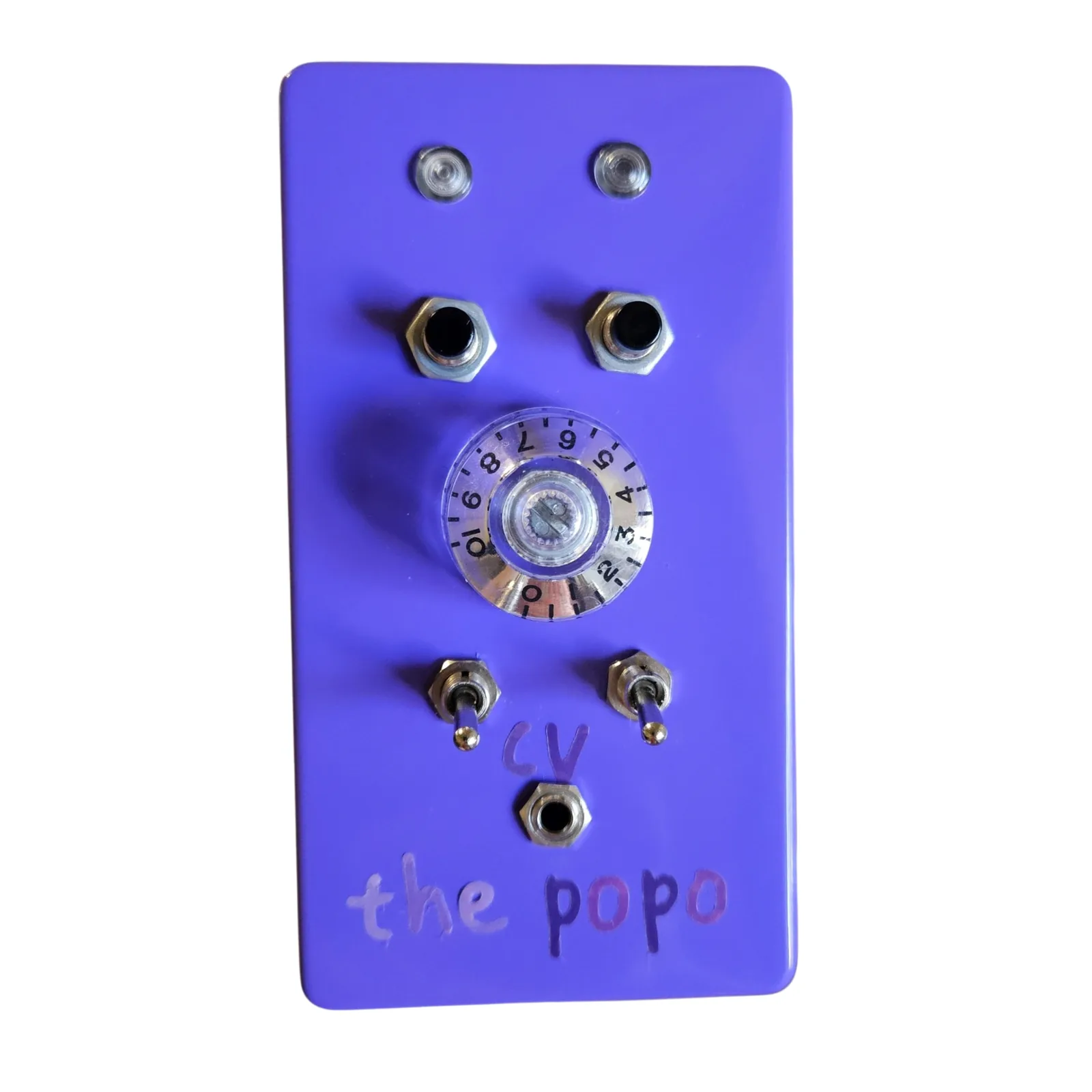 An upright glossy purple box photographed face on. Two clear lights sit side by side at the top, two black push buttons below them, and a large clear knob with a numbered skirt in the middle. Under the knob are two toggles with cv lettered between them over a small jack, and the popo is hand-lettered across the bottom in pink and purple.