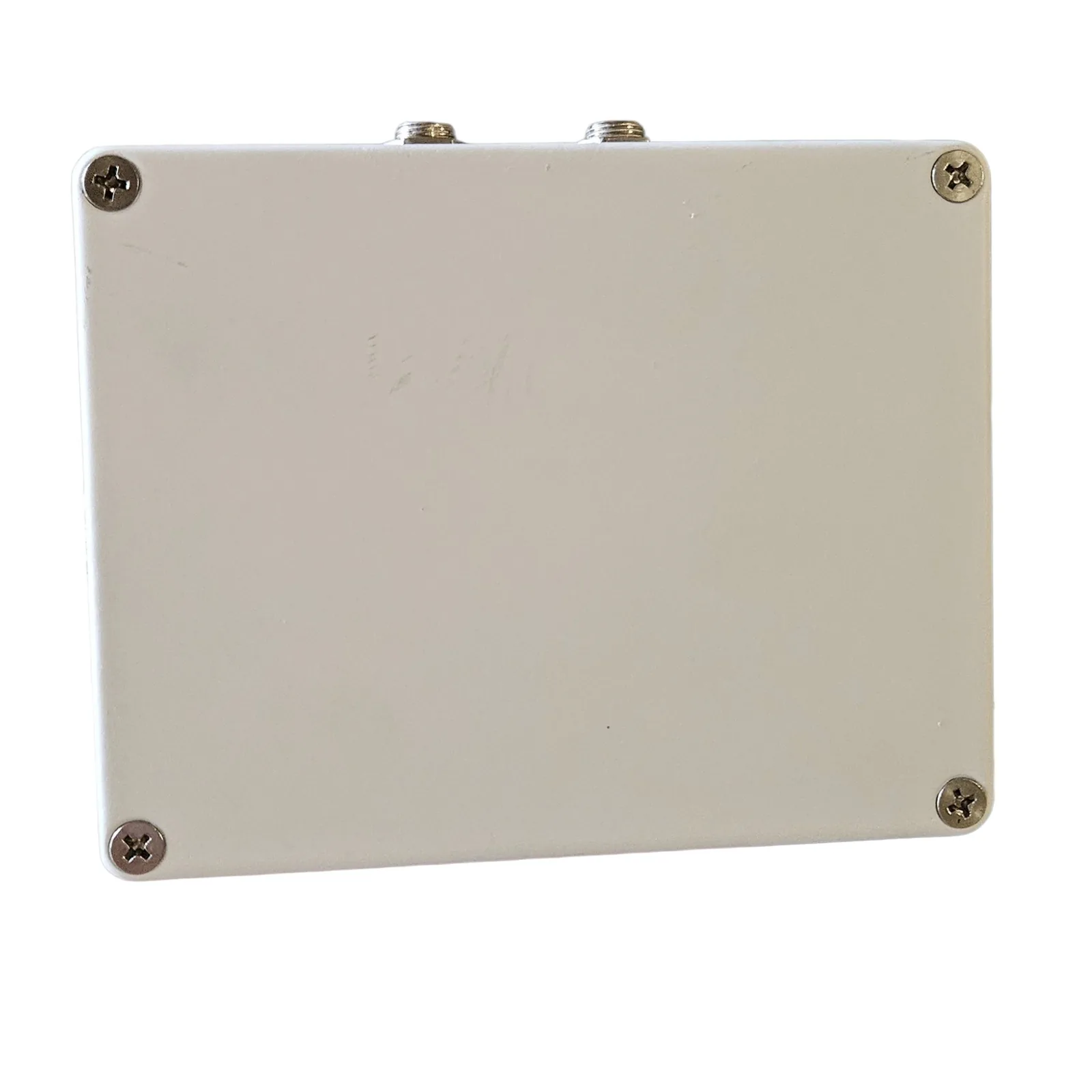 The back plate of the box, plain white with a screw at each corner and the nuts of the two jacks showing on the edge above.