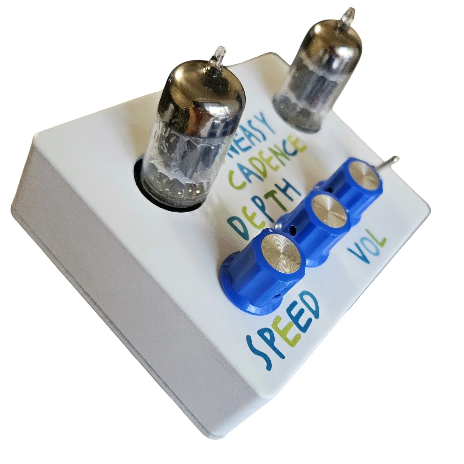 The box from its left end, the nearer tube looming large at the left. UNEASY CADENCE and DEPTH run across the face beside it, and the three blue knobs recede in a row toward the toggle, with SPEED lettered in front of the nearest knob and VOL beyond.