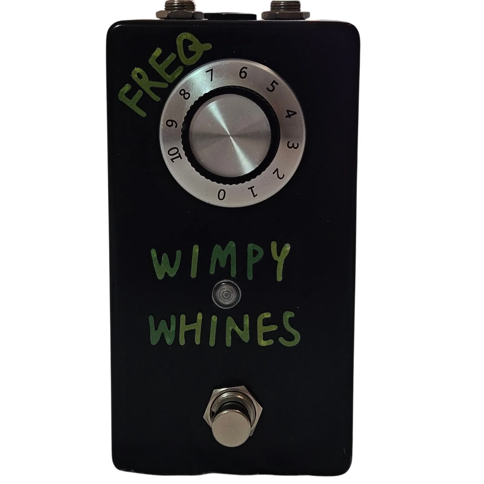 A tall black pedal photographed face on. Hand-painted green capital letters read FREQ. down the top left corner and WIMPY WHINES across the middle in two lines. A large silver-topped knob sits on a numbered dial skirt reading 0 to 10, a small round LED sits between the two words, and a silver footswitch stands at the bottom.