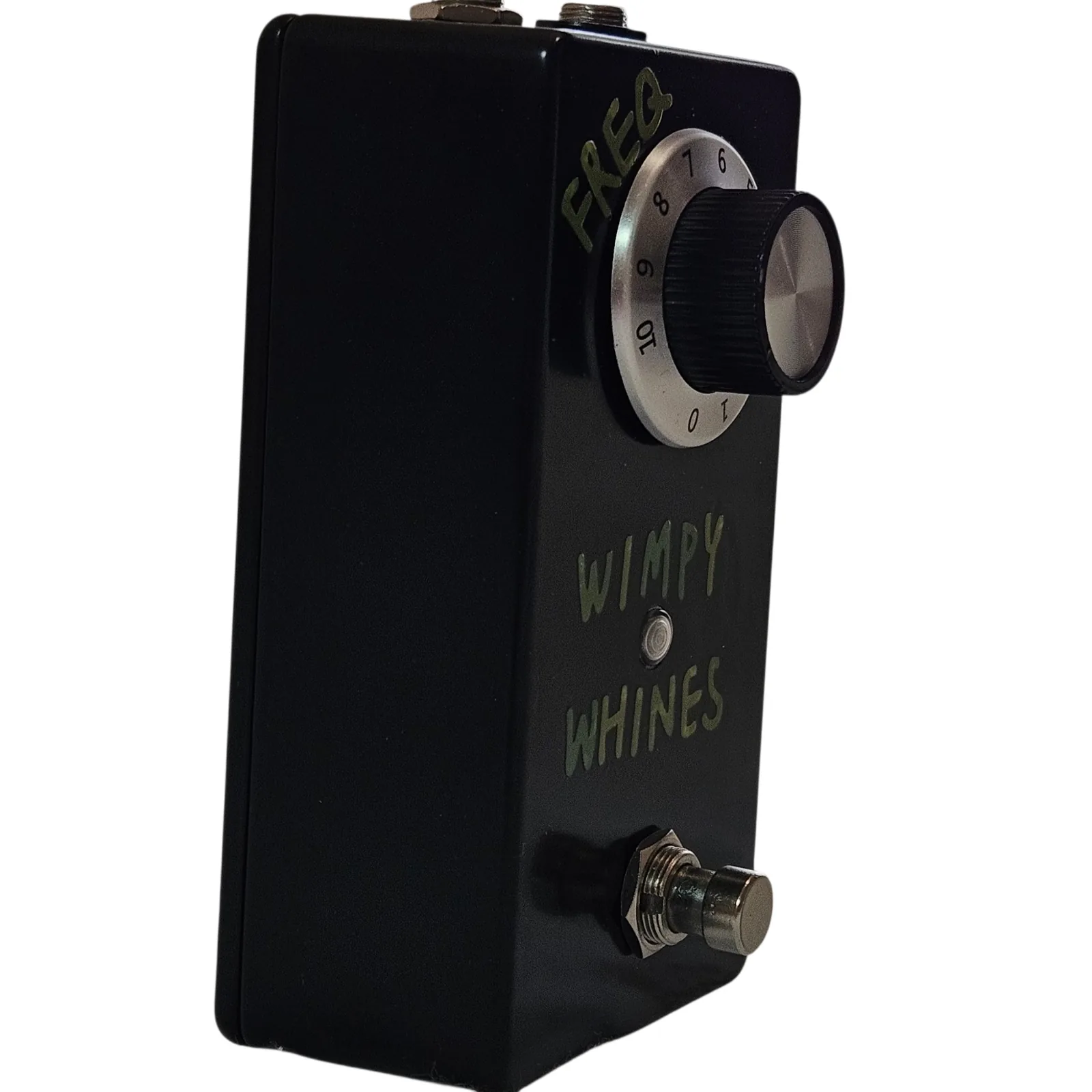 The same pedal turned three quarters to show its depth. The green WIMPY WHINES lettering and the knob are still readable on the face, and the plain black flank runs back from them to the footswitch standing proud at the near corner.