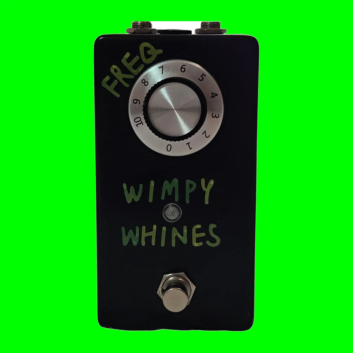A tall black pedal photographed face on. Hand-painted green capital letters read FREQ. down the top left corner and WIMPY WHINES across the middle in two lines. A large silver-topped knob sits on a numbered dial skirt reading 0 to 10, a small round LED sits between the two words, and a silver footswitch stands at the bottom.